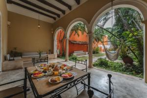 a dining room with a table with food on it at Casa Jade Hotel - Adults Only, Mérida in Mérida +23 photos