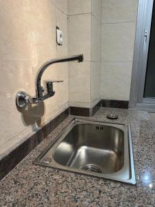 a kitchen sink with a faucet on a counter at Fokam Hôtel in Nkongoa