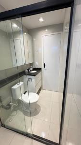 a bathroom with a toilet and a glass door at Flat Eufrates 205 in Olinda +8 photos