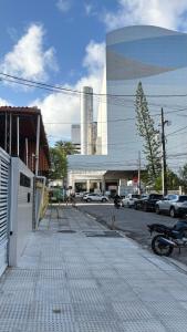a parking lot with a building and a street with cars at Flat Eufrates 205 in Olinda