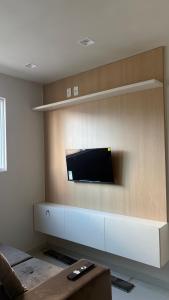 a living room with a flat screen tv on a wall at Flat Eufrates 205 in Olinda