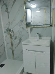 a white bathroom with a sink and a mirror at Madriel Eko Retreat in Bokonbayevo +20 photos