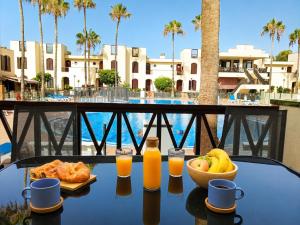 a table with a bowl of fruit and orange juice at STUDIO TAGORO in Costa Del Silencio