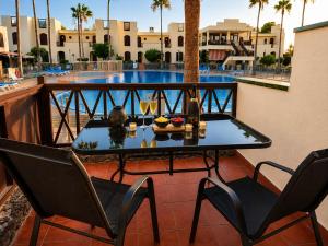 a table and chairs on a balcony with a pool at STUDIO TAGORO in Costa Del Silencio