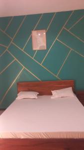 a bedroom with a bed with a green and yellow wall at Chez ABDOUL in Rufisque
