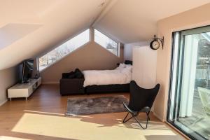 a bedroom with a bed and a chair in a attic at Villa Circus in Halmstad