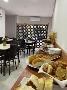 a table with several plates of bread and sandwiches at Neves Hotel II in Ipatinga