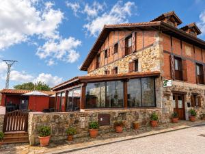 a brick house with windows and potted plants at Posada El Nozal in Seña