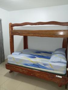 a wooden bunk bed with blue and yellow sheets at House Puerto Viejo in Puerto Viejo