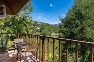 a patio with two chairs and a table on a balcony at NB Villa Lilawadee in Chaweng Noi Beach