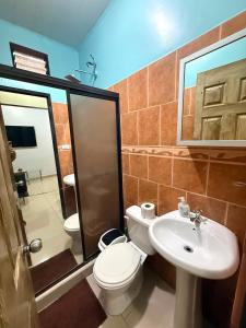 a bathroom with a toilet and a sink and a shower at House Puerto Viejo in Puerto Viejo