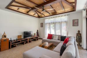a living room with a couch and a tv at NB Villa Lilawadee in Chaweng Noi Beach