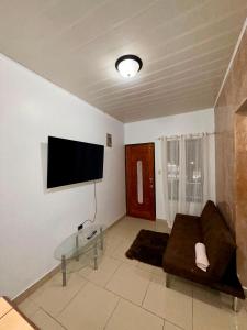 a living room with a couch and a flat screen tv at House Puerto Viejo in Puerto Viejo