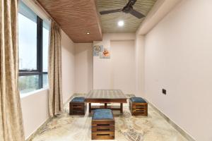 a room with a table and two chairs and a window at Luxora Suites in Jaipur