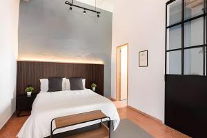 ein Schlafzimmer mit einem großen weißen Bett mit hölzernem Kopfteil in der Unterkunft Casa 212 con WIFI alta velocidad y estacionamiento in Puebla