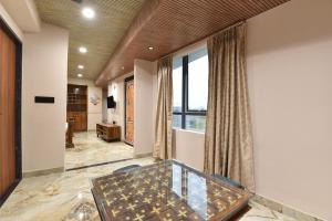 a room with a glass table and a large window at Luxora Suites in Jaipur