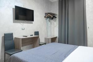 una camera da letto con un letto, una scrivania e una TV di Hotel Planet a Roma