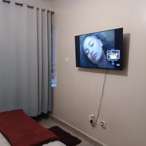 a flat screen tv hanging on a wall in a room at Studio apartment at Arc Residence in Nairobi