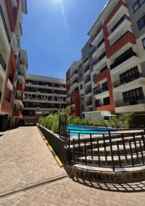 a building with a swimming pool in front of a building at Studio apartment at Arc Residence in Nairobi