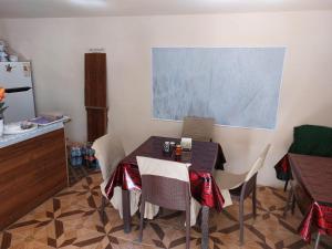 a dining room with a table with chairs and a chalkboard at Umid Hostel in Termiz