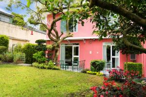 a pink house with a green yard at Casa Aliso Hotel Boutique in Quito