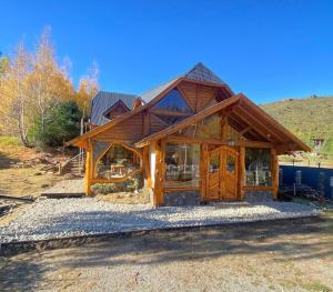 a log cabin with a large wooden door at Hosteria Sudbruck in San Carlos de Bariloche