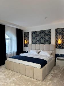 a large bedroom with a large bed with a large white bed sidx sidx at K41House in Almaty