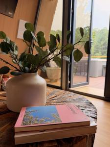 a table with two books and a vase with a plant at La Estela NatureSuite in Mazamitla