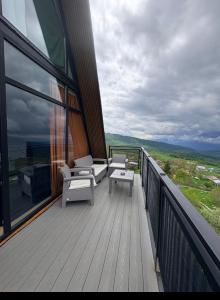 a balcony with chairs and tables on a building at Mravaldzali twins in Oni