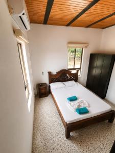 a bedroom with a bed with two blue towels on it at Naru CasaBlanca in Utica