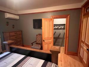 a bedroom with a bed and a chair and a window at La Tournesol in Granby +1 photo