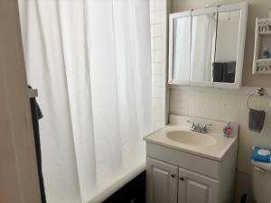 a bathroom with a white shower curtain and a sink at The Traveler Suite C1 in Hartford +14 photos