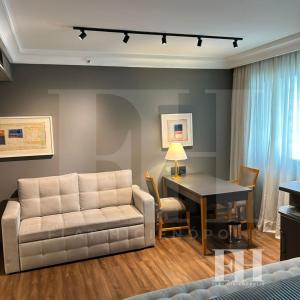 a living room with a couch and a table at Flat Higienópolis in São Paulo