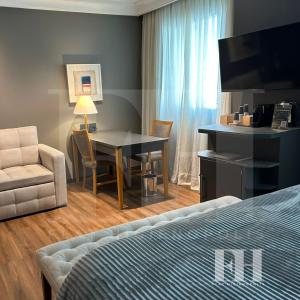 a bedroom with a table and a chair and a bed at Flat Higienópolis in São Paulo +12 photos
