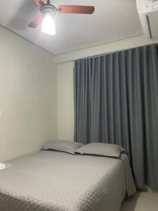 a bedroom with a bed and a ceiling fan at Neves Hotel II in Ipatinga