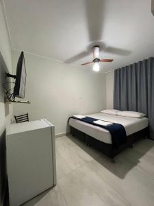a bedroom with a bed and a ceiling fan at Neves Hotel II in Ipatinga