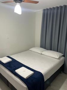 a bed with two towels on it in a room at Neves Hotel II in Ipatinga