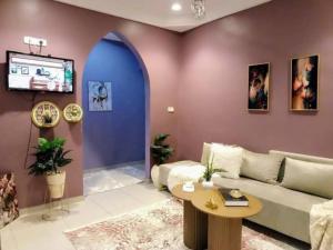 a living room with a couch and a tv at Maisons Maktoub Djerba in Al Maqārisah
