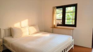 a white bed in a room with a window at Zen Hideaway - Cute Modern Thai Home in Ko Phangan