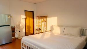 a bedroom with a large white bed with a fan at Zen Hideaway - Cute Modern Thai Home in Ko Phangan