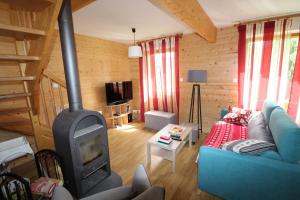 a living room with a blue couch and a fireplace at Chalet avec mezzanine 4 étoiles, Saint Mamet, jusqu'à 10 couchages, proche du lac de Gérardmer des commerces et des pistes de ski dans un quartier calme in Gérardmer