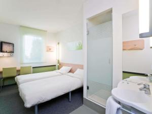 a hospital room with two beds and a sink at ibis budget Torun in Toruń