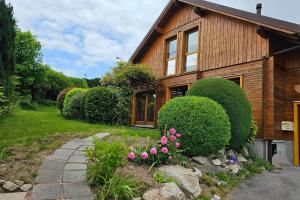 a wooden house with flowers in front of it at Chalet avec mezzanine 4 étoiles, Saint Mamet, jusqu'à 10 couchages, proche du lac de Gérardmer des commerces et des pistes de ski dans un quartier calme in Gérardmer