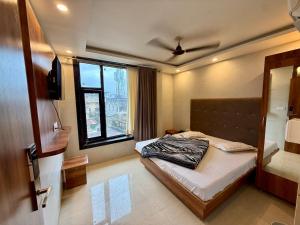 ein Schlafzimmer mit einem Bett und einem Fenster in der Unterkunft Hotel A1 Star in Ajmer
