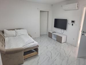 a white room with a bed and a television at Vila Gaia in Sarajevo