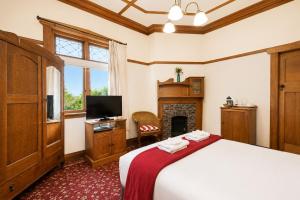 a bedroom with a bed and a tv and a fireplace at Halswell Lodge in Wellington