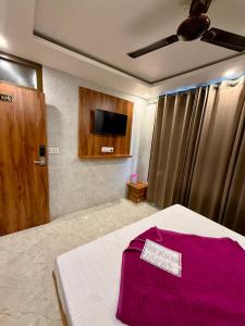 ein Schlafzimmer mit einem Bett und einem Fernseher an der Wand in der Unterkunft Hotel A1 Star in Ajmer