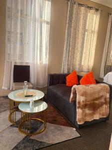 a living room with a couch and two tables at Mapungubwe apartment in Johannesburg