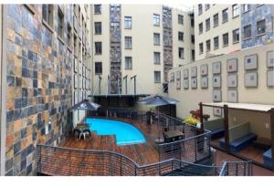 a view of a swimming pool in the middle of a building at Mapungubwe apartment in Johannesburg