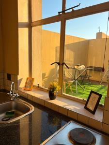 a kitchen counter with a sink and a window with a table at Mapungubwe apartment in Johannesburg +40 photos